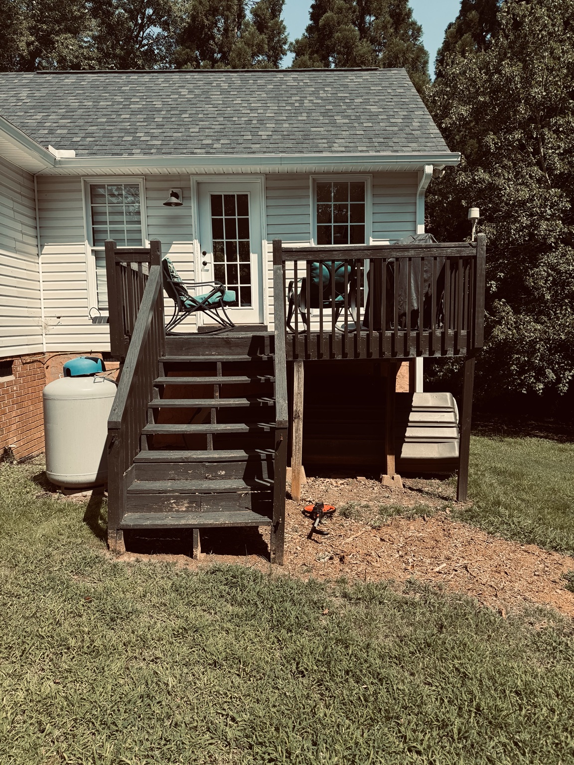 A completed timber deck and staircase beside a home